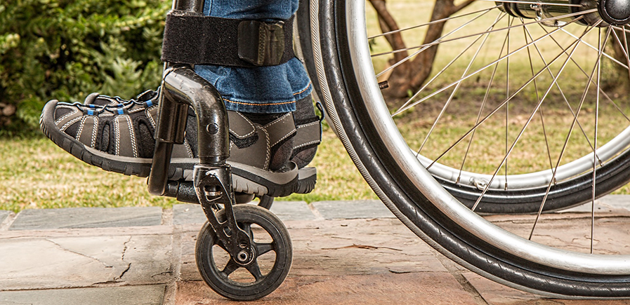 Die Räder von einem Rollstuhl und aufgestellte Füße